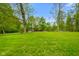 Expansive front yard with lush green grass and mature trees providing privacy at 12142 N Paddock Rd, Camby, IN 46113