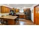Well-lit kitchen features wooden cabinets, stainless steel appliances, and a breakfast bar at 12142 N Paddock Rd, Camby, IN 46113