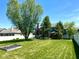 Large backyard featuring mature trees, a lush lawn, a fire pit, and a covered patio area at 13766 Heatherfield Dr, Fishers, IN 46038