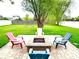 Landscaped backyard featuring a brick fire pit and Adirondack chairs, perfect for outdoor gatherings at 13766 Heatherfield Dr, Fishers, IN 46038