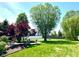 Expansive backyard with lush green grass, patio area, mature trees, and privacy fence at 13766 Heatherfield Dr, Fishers, IN 46038