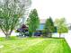 Expansive backyard view showcasing the patio with fire pit, seating area, and well-manicured lawn at 13766 Heatherfield Dr, Fishers, IN 46038