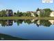 Scenic view of homes reflecting in a calm pond, showcasing the peaceful community atmosphere at 13766 Heatherfield Dr, Fishers, IN 46038