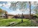 Backyard featuring a well-maintained lawn, mature trees, and a brick home with a covered patio at 1416 Wellington Ave, Indianapolis, IN 46219