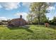Backyard featuring a well-maintained lawn, mature trees, and a playhouse at 1416 Wellington Ave, Indianapolis, IN 46219