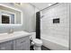 Updated bathroom features modern white tile, a sleek gray vanity, and a shower with a black accent at 1416 Wellington Ave, Indianapolis, IN 46219