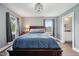 Bright bedroom with hardwood floors, a stylish light fixture, and large windows offering plenty of natural light at 1416 Wellington Ave, Indianapolis, IN 46219