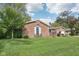 Charming brick house with arched window and two car garage on a well-maintained lawn at 1416 Wellington Ave, Indianapolis, IN 46219