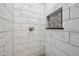 Shower featuring marble tile walls, a rainfall shower head, and a convenient stone-lined storage niche at 1416 Wellington Ave, Indianapolis, IN 46219