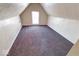 Cozy attic bedroom featuring neutral carpet, white walls, and a window that provides natural light at 1425 S Belmont Ave, Indianapolis, IN 46221
