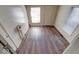 Small bedroom featuring hardwood floors, white walls, and multiple doorways and windows at 1425 S Belmont Ave, Indianapolis, IN 46221