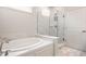 Modern bathroom features a luxurious soaking tub and a sleek glass-enclosed shower with marble tile surround at 14878 Anees Ln, Fishers, IN 46040