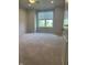 Spacious bedroom featuring neutral carpet, ceiling fan, and a large window with exterior views at 14878 Anees Ln, Fishers, IN 46040