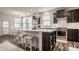Modern kitchen features an island with seating, stainless steel appliances, and dark cabinets at 14878 Anees Ln, Fishers, IN 46040