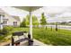 Back patio with outdoor seating overlooking lush lawn and pond for relaxing and enjoying the view at 14878 Anees Ln, Fishers, IN 46040