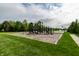 Community playground with a variety of equipment surrounded by lush green grass at 14878 Anees Ln, Fishers, IN 46040