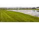 Scenic pond view in a residential neighborhood with lush green grass and fountain at 14878 Anees Ln, Fishers, IN 46040
