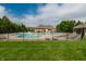 Community pool area with lounge chairs, landscaping, and clubhouse under a blue sky at 14878 Anees Ln, Fishers, IN 46040