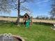 Fenced backyard with lush lawn, mature trees, and a playset perfect for Gathering fun at 1502 Austin Dr, Lebanon, IN 46052