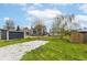 Wide backyard featuring a gravel path, storage sheds, well-maintained lawn, and neighboring homes at 1523 S K St, Elwood, IN 46036