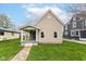 Charming tan single-story home featuring a welcoming front porch and well-manicured lawn at 1523 S K St, Elwood, IN 46036