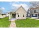 Charming tan single-story home featuring a welcoming front porch and well-manicured lawn at 1523 S K St, Elwood, IN 46036