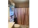 Small, cozy bathroom with pink shower curtain, toilet, vanity and extra storage space at 15406 Destination Dr, Noblesville, IN 46060