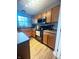Well-lit kitchen featuring ample wooden cabinetry, black appliances, and modern countertops at 15406 Destination Dr, Noblesville, IN 46060