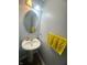 Half bathroom featuring a pedestal sink, oval mirror, modern lighting, and grey walls at 15406 Destination Dr, Noblesville, IN 46060
