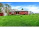 Wide view of the red home featuring a large front yard and a utility shed at 1630 N 400 W, Bargersville, IN 46106