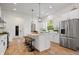 Spacious kitchen with stainless appliances, white cabinetry, large island with seating, and modern lighting at 2044 Alvord St, Indianapolis, IN 46202