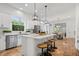 Bright kitchen boasts white cabinets, stainless appliances, island with seating, and modern pendant lighting at 2044 Alvord St, Indianapolis, IN 46202