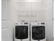 Modern laundry room featuring side-by-side washer and dryer with storage racks at 2044 Alvord St, Indianapolis, IN 46202