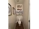 Small half bathroom with toilet, shelving and decorative wall art in a cozy space at 2068 Deer Valley Ct, Columbus, IN 47201