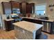 Modern kitchen with a center island, stainless steel appliances, tile backsplash, and dark wooden cabinetry at 2068 Deer Valley Ct, Columbus, IN 47201