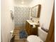 Well-lit bathroom with a vanity, toilet, framed mirror, and shower featuring a decorative curtain at 223 E 53Rd St, Anderson, IN 46013