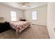 Bright bedroom featuring neutral carpet, two windows, and a bed with a decorative comforter at 223 E 53Rd St, Anderson, IN 46013