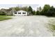 Charming single-story home with white siding, black shutters and a gravel driveway at 223 E 53Rd St, Anderson, IN 46013