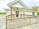 Welcoming front porch with wooden railings and ramp provides accessible entry to the home at 223 E 53Rd St, Anderson, IN 46013