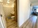Hallway view of a bathroom with a walk-in shower, vanity, and toilet, and a glimpse of the living room at 223 E 53Rd St, Anderson, IN 46013