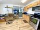 Well-lit kitchen featuring stainless steel appliances, wood cabinets, and new laminate flooring at 223 E 53Rd St, Anderson, IN 46013