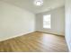 Bedroom features wood-look floors, a bright window, and neutral walls at 3019 Knobstone Ln, Indianapolis, IN 46203
