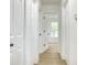 Hallway featuring multiple white doors with black hardware and wood-look flooring at 3019 Knobstone Ln, Indianapolis, IN 46203