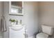Neutral powder room with a white single sink vanity, a decorative mirror and toilet at 328 N Layman Ave, Indianapolis, IN 46219