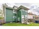 Two-story home features green siding, white trim, well-maintained lawn, and mature trees at 328 N Layman Ave, Indianapolis, IN 46219