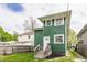 Two-story home showcasing green siding, stairs leading to the entrance, and a well-maintained yard at 328 N Layman Ave, Indianapolis, IN 46219