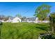 Spacious backyard featuring lush green grass, privacy fence, patio with pergola, and detached garage at 335 N Franklin Rd, Indianapolis, IN 46219