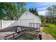 A detached one-car garage with white siding and door, next to an asphalt drive and trailer on green grass at 335 N Franklin Rd, Indianapolis, IN 46219