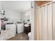Convenient laundry room and bathroom featuring a washer, dryer, shower, and ample storage space at 335 N Franklin Rd, Indianapolis, IN 46219