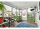 Bright sunroom with large windows, potted plants, and a cozy atmosphere perfect for relaxing or gardening at 335 N Franklin Rd, Indianapolis, IN 46219